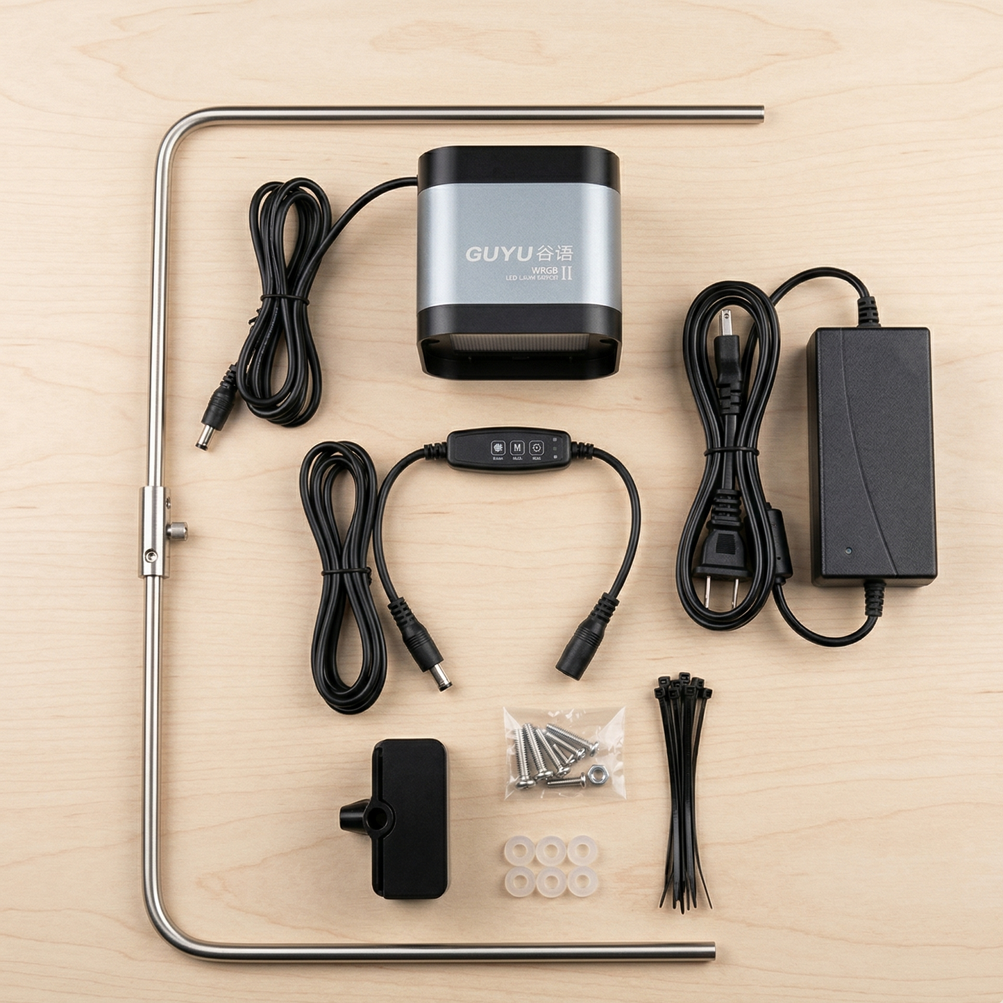 Vue aérienne flat lay professionnel du kit complet LED WRGB II déballé montrant tous composants : unité LED gris argenté, bracket acier inoxydable ajustable, pince fixation noire, adaptateur secteur, câble avec variateur intégré, vis de montage, attaches câbles noires, pads caoutchouc, disposés symétriquement organisés sur surface neutre claire, éclairage studio uniforme, style photographie e-commerce premium unboxing, format JPG carré 1:1