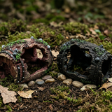 Deux cachettes tronc tonneau résine côte à côte comparaison, version 
marron rouge mousse verte gauche et version sombre noire droite, 
légèrement inclinées ouvertures vers extérieur, surface sol forêt 
sombre mousse pierres feuilles entre deux, lumière naturelle forêt 
dessus textures riches détaillées, format PNG 1:1