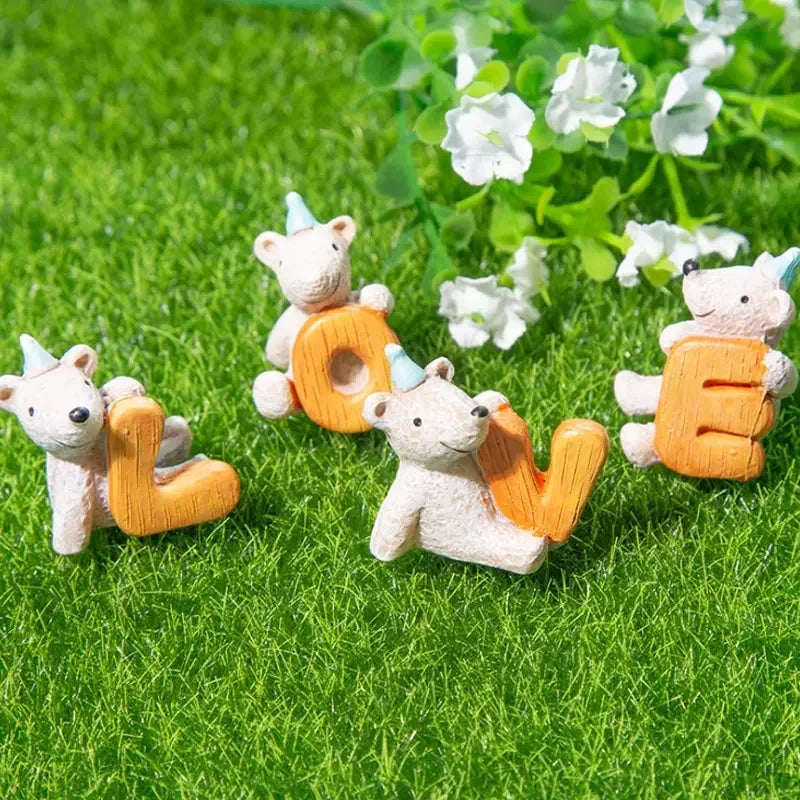 Tapis gazon artificiel vert naturel sol, quatre figurines résine ours 
polaires chapeaux coniques bleus tenant lettres orange formant LOVE, 
fleurs blanches trèfle fond doux flou, micro-monde enchanteur 
décoratif, lumière naturelle douce, format JPG 1:1