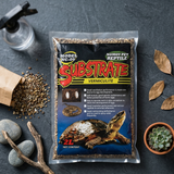 Vue plongeante flat lay sachet substrat vermiculite premium entouré 
accessoires terrarium naturels, pierres rivière bois séché feuilles 
terracotta succulent, substrat loose texture visible, surface ardoise 
grise, lumière naturelle overhead, format JPG 1:1